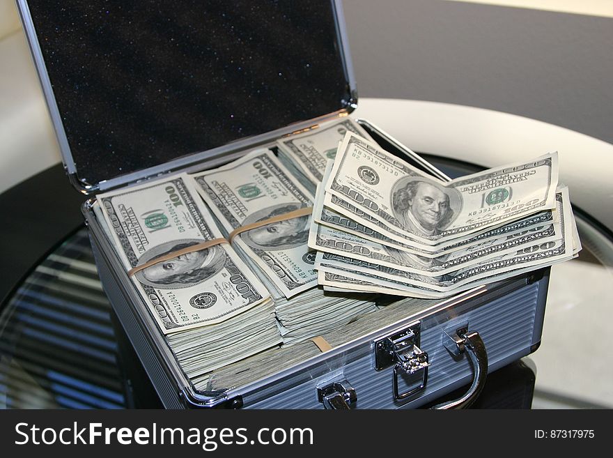 Piles Of U.s. Dollar Bills On Silver And White Suitcase