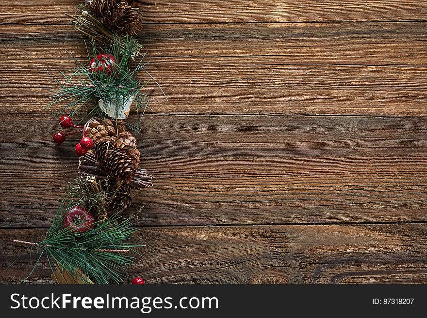 A christmas background with conifer branches and cones on wooden background.