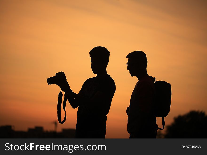 A pair of men photographing at sunset. A pair of men photographing at sunset.
