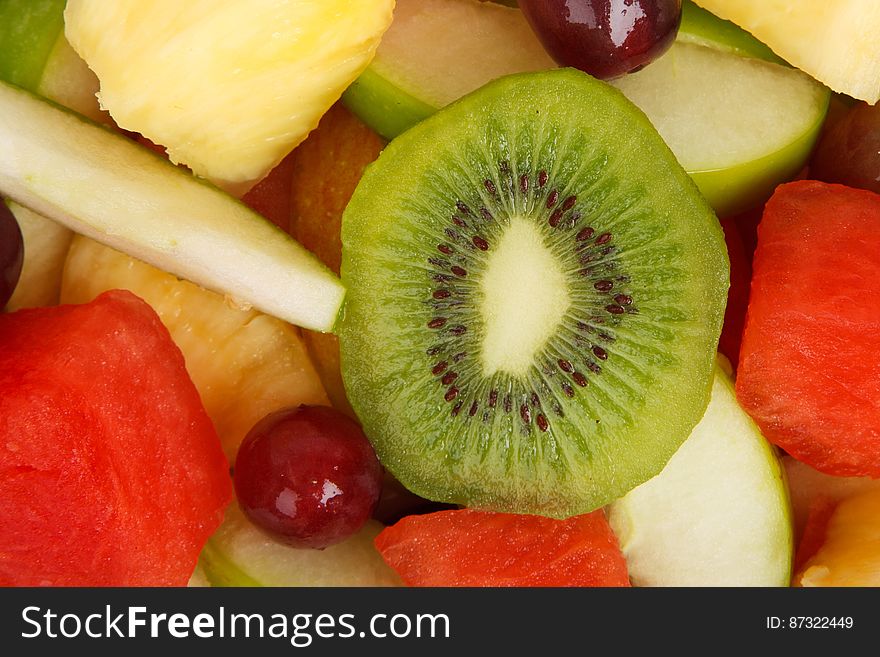 A fruit salad with apple, melon, grapes and kiwi.