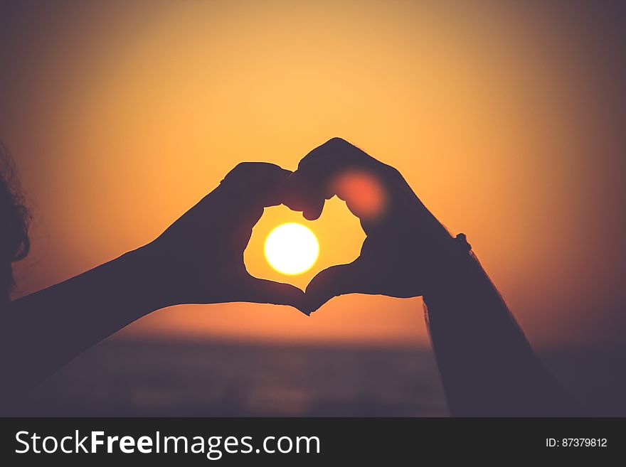 Two Hands Making A Heart With Sunset In Background