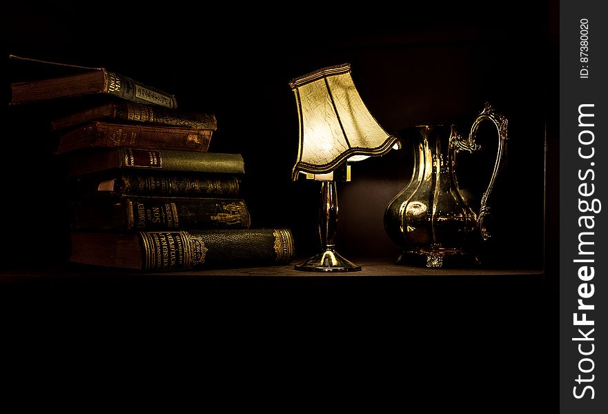 Desk With Lamp, Pitcher, And Vintage Books