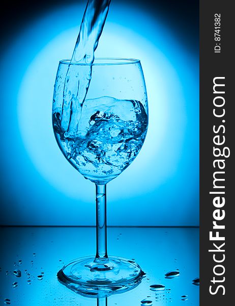 Glass with water on a blue background