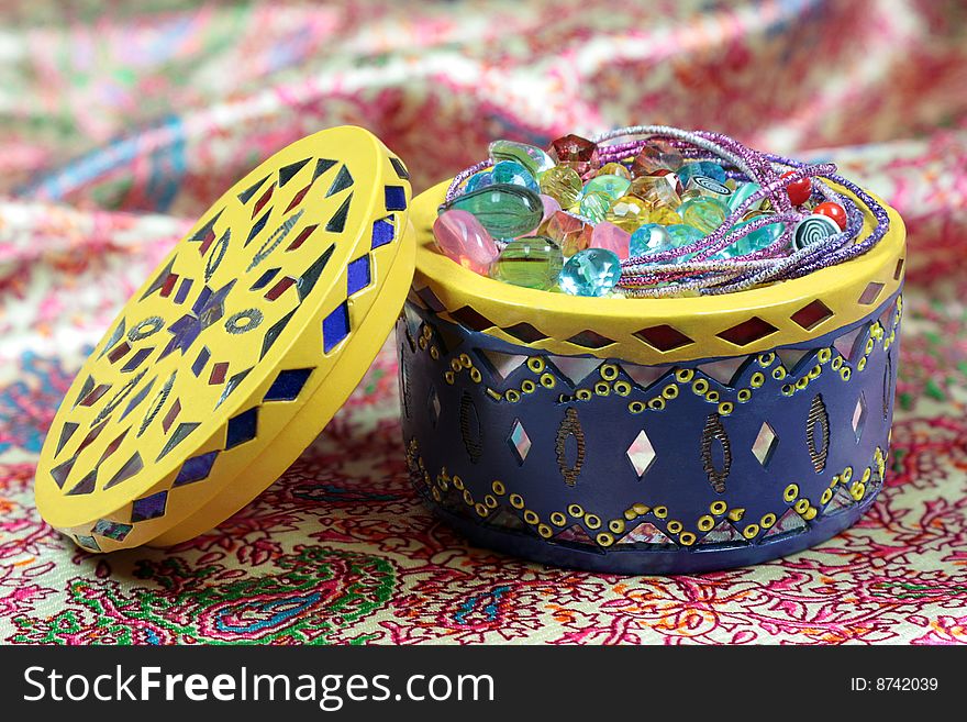 Casket with fake jewelry on a silk background