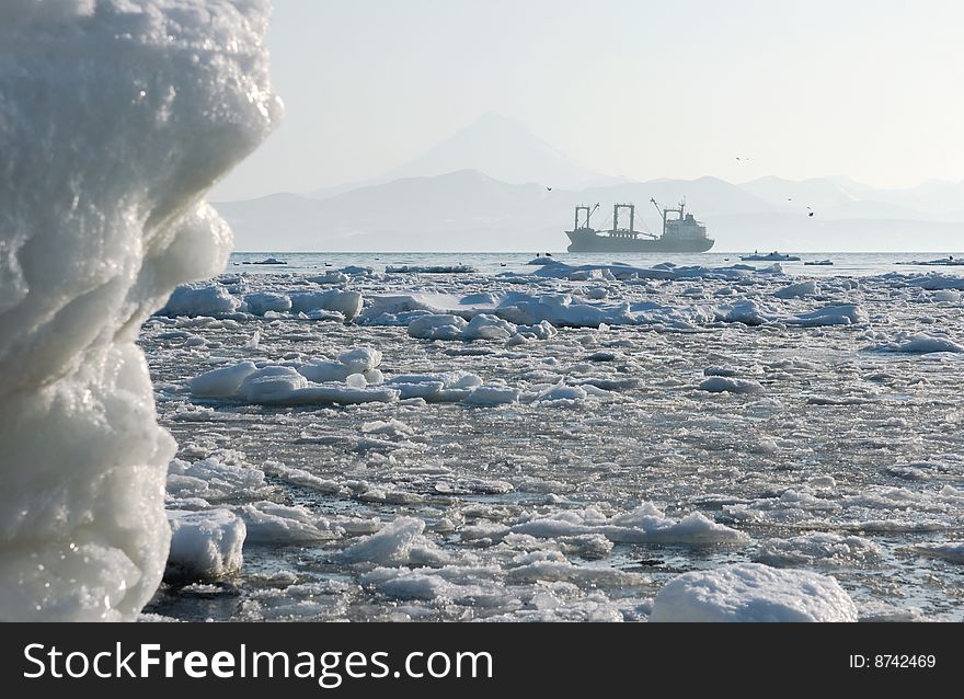 Industrial ship beside coast Kamchatka amongst snow drift ice. Industrial ship beside coast Kamchatka amongst snow drift ice