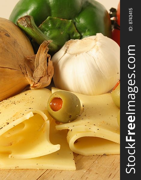 Close up of cheese and vegetables garnished with olives and ground pepper