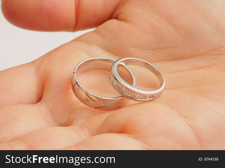 His and Hers wedding rings held in female hand. His and Hers wedding rings held in female hand