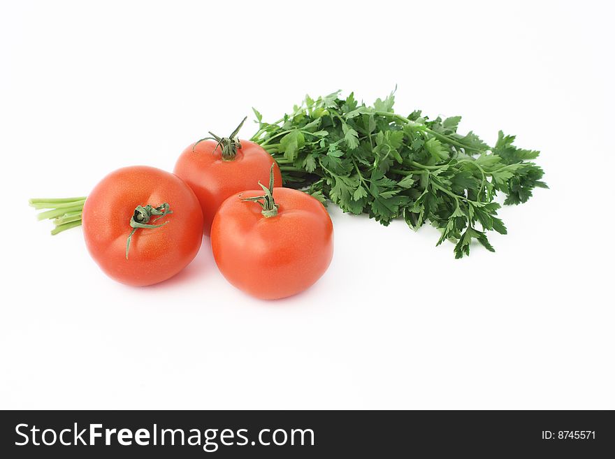 Three tomatoes with parsley over white background