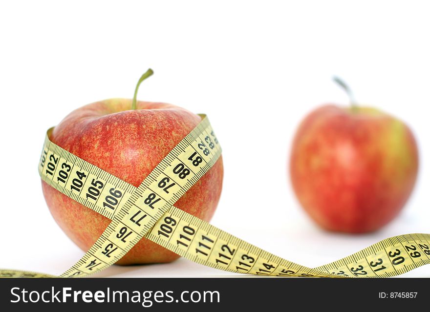 Measuring tape round an apple and the second apple on a back background