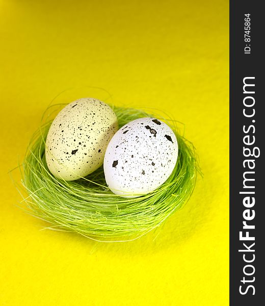 Easter eggs with green nest on yellow paper