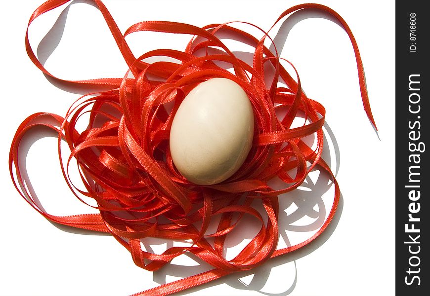 A chicken egg lies on a red ribbon. We prepare to the holiday to Easter. A chicken egg lies on a red ribbon. We prepare to the holiday to Easter.