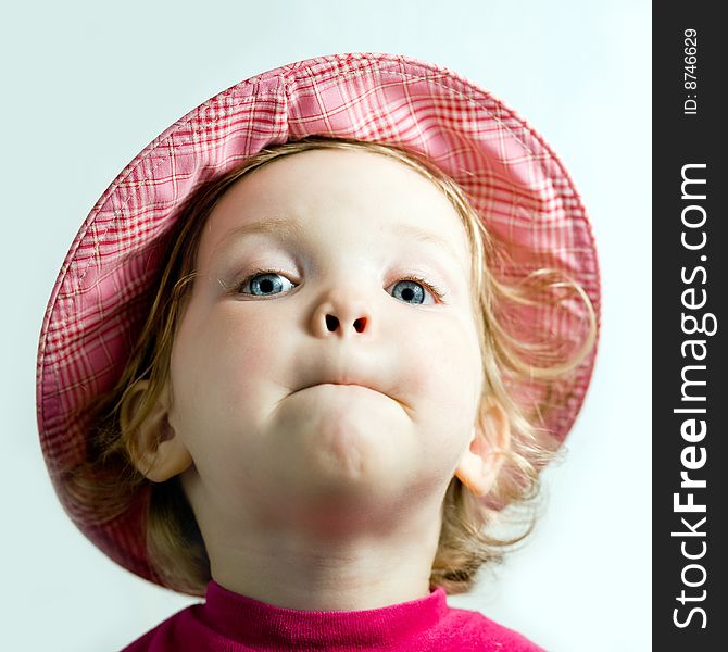 Stock photo: an image of a playful  baby in a pink hat. Stock photo: an image of a playful  baby in a pink hat
