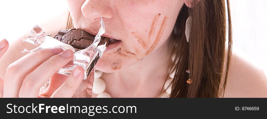 Closeup mouth of woman eating a chocolate. Isolated. Closeup mouth of woman eating a chocolate. Isolated