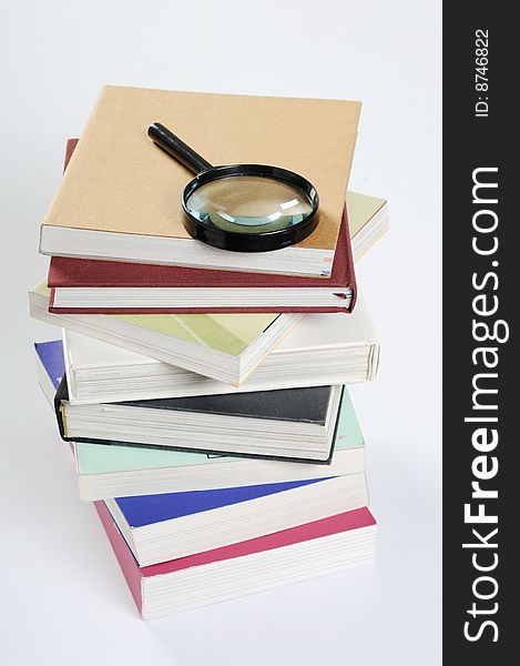 Magnifier & stack of books with white background. Magnifier & stack of books with white background