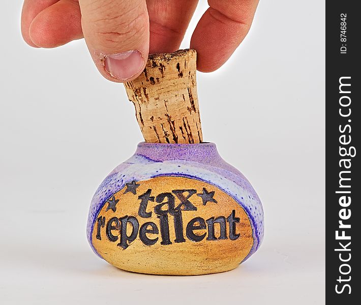 Close-up of hand removing corked bottle labelled, tax repellent. Close-up of hand removing corked bottle labelled, tax repellent