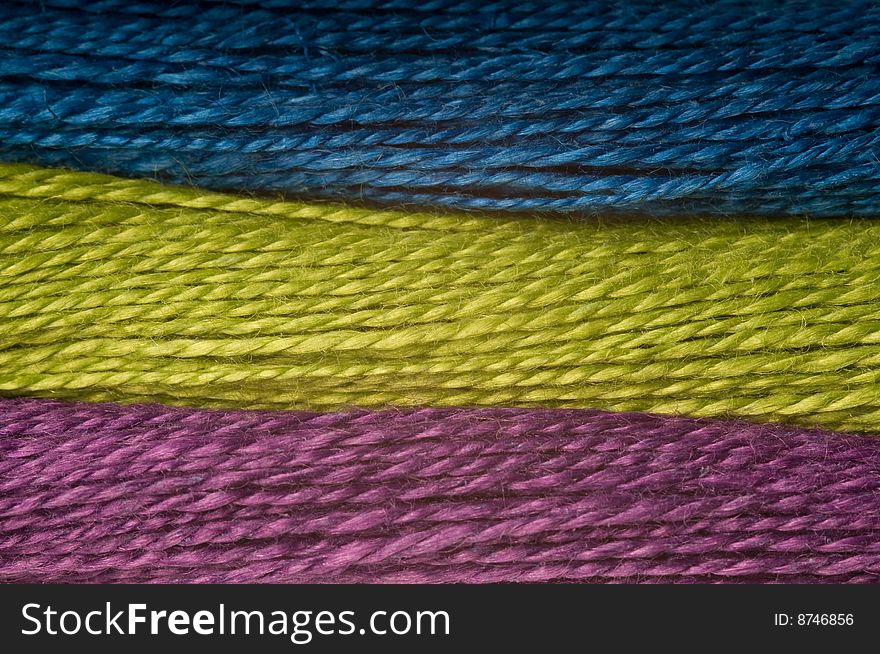 Horizontal rows of threads in blue, green and purple. Horizontal rows of threads in blue, green and purple