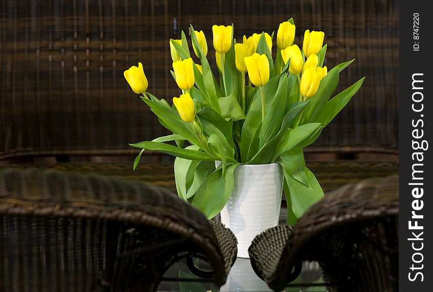 Bouquet of fresh yellow tulips on the glass table