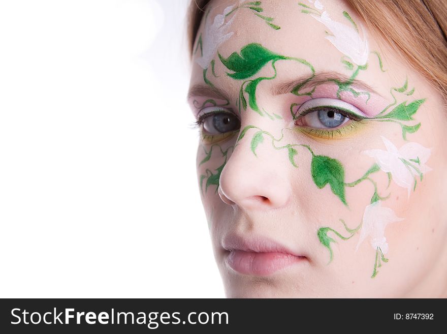 A beautiful young girl with a picture of green flowers on her face. A beautiful young girl with a picture of green flowers on her face