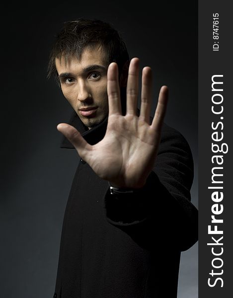 Portrait of a young business man with his hands on a dark background. Portrait of a young business man with his hands on a dark background