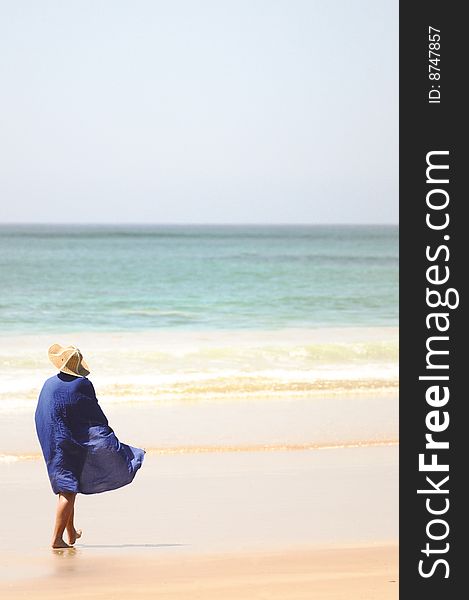 A woman walking down the South African beach early in the morning. A woman walking down the South African beach early in the morning