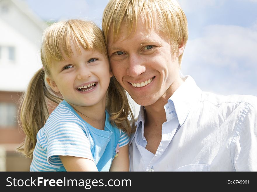 Portrait of happy man with his daughter looking at camera outdoors. Portrait of happy man with his daughter looking at camera outdoors