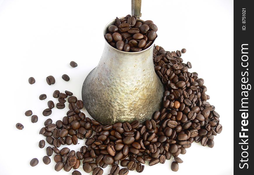 Coffee beans in old coffee pot on white background