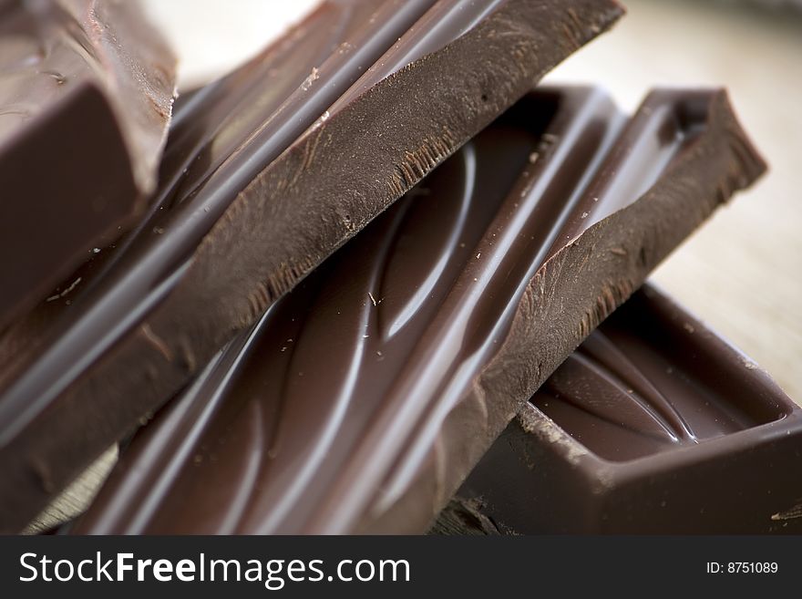 A diagonal composition of chocolate bricks on a wooden background. A diagonal composition of chocolate bricks on a wooden background