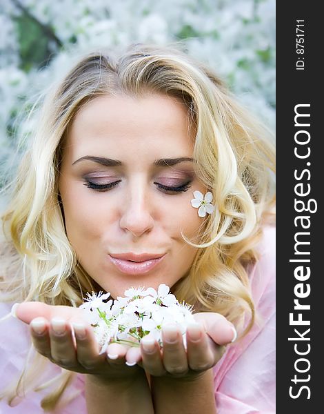 Yound blonde with cherry flowers in hands