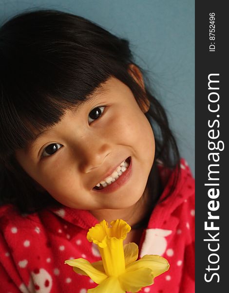 Asian Girl holding a dafadill Flower with a big smile on her face. Asian Girl holding a dafadill Flower with a big smile on her face