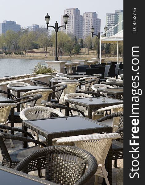 A line of tables with chairs of wicker in the open air。. A line of tables with chairs of wicker in the open air。