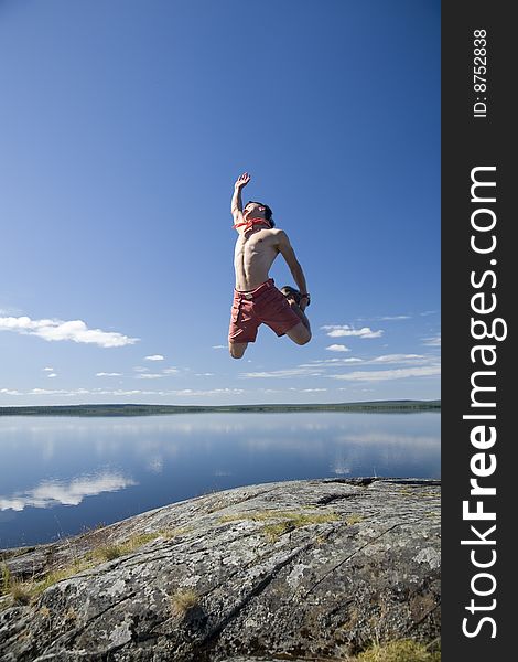 Young man jumping on a rock
