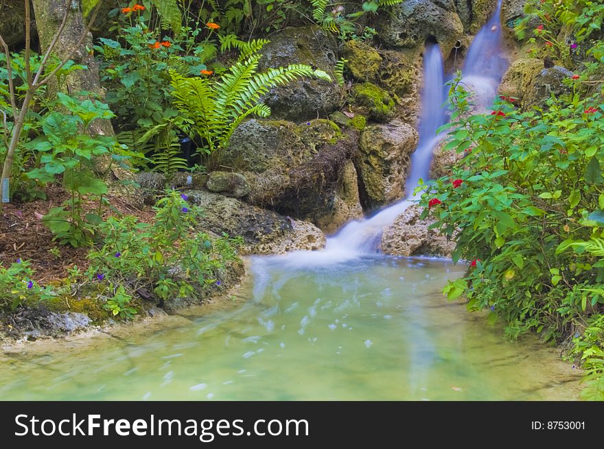 A waterfall through rocks and plant life