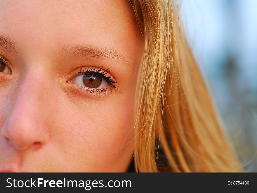 Tightly cropped face portrait of attractive young blond girl. Only half of the face is visible. Tightly cropped face portrait of attractive young blond girl. Only half of the face is visible