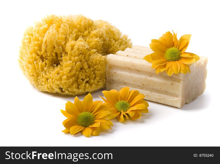 Natural sponge, soap and flowers on white background