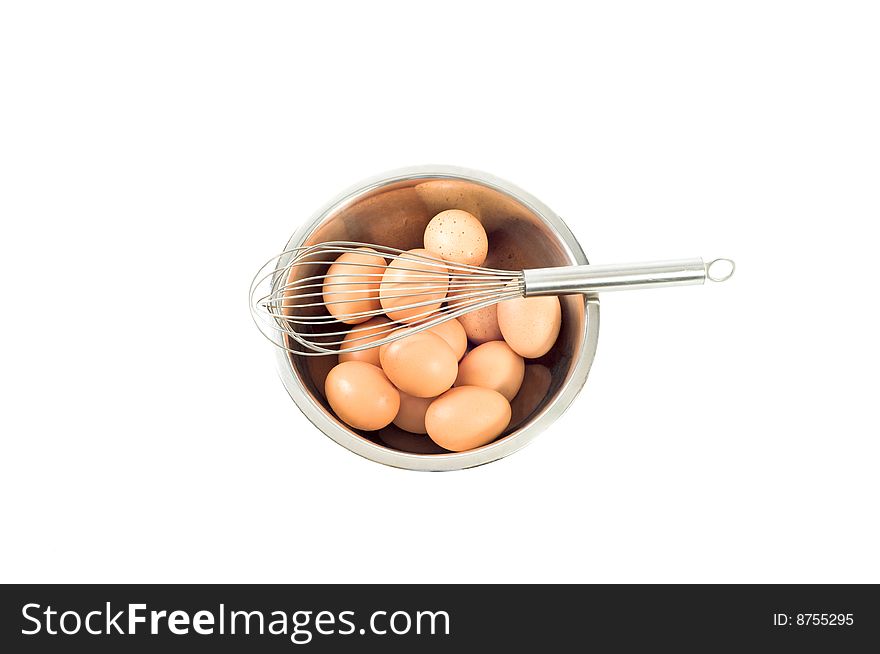 Eggs in a bowl with a whisk isolated on white