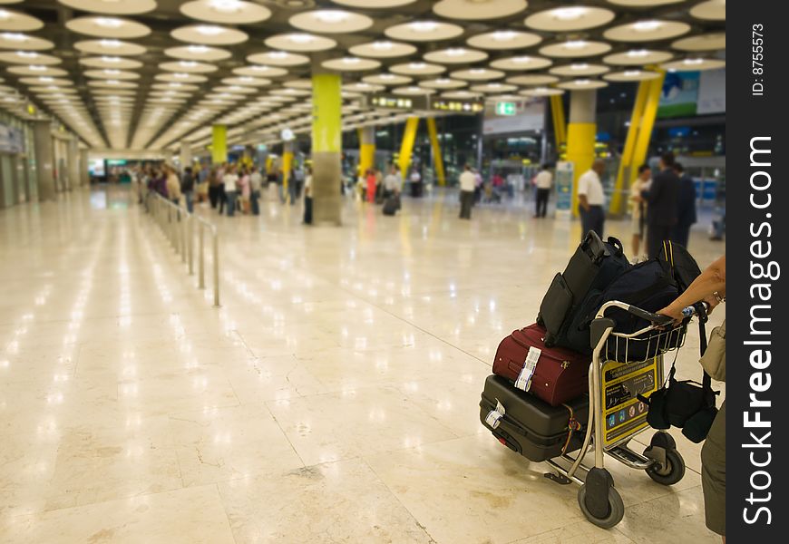 Hall at Barajas T4 airport. People in motion or blured. Focus on baggages. Hall at Barajas T4 airport. People in motion or blured. Focus on baggages