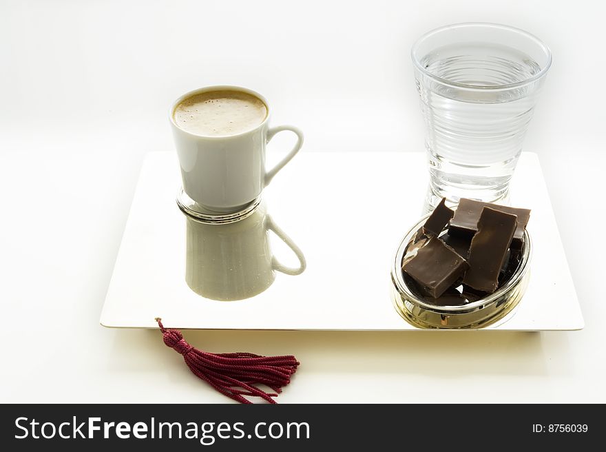 Coffee, chocolate and cup of water on a plat