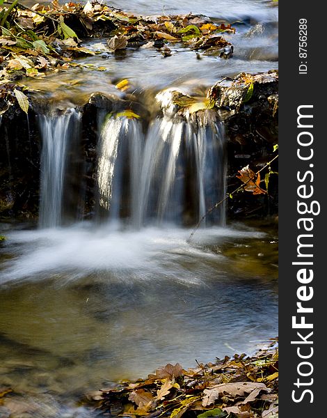 Highland stream with the leaves on bank on autumn