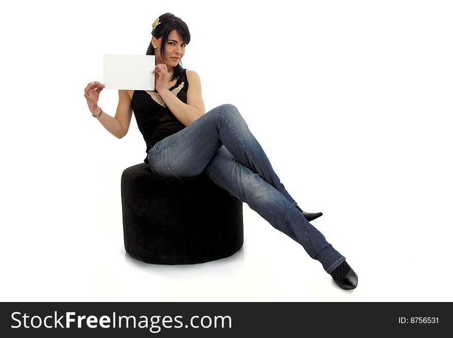 Full body view of attractive woman holding a blank sign and sitting on a pouf in casual wear. Free space for custom message. Isolated on white background. Full body view of attractive woman holding a blank sign and sitting on a pouf in casual wear. Free space for custom message. Isolated on white background.