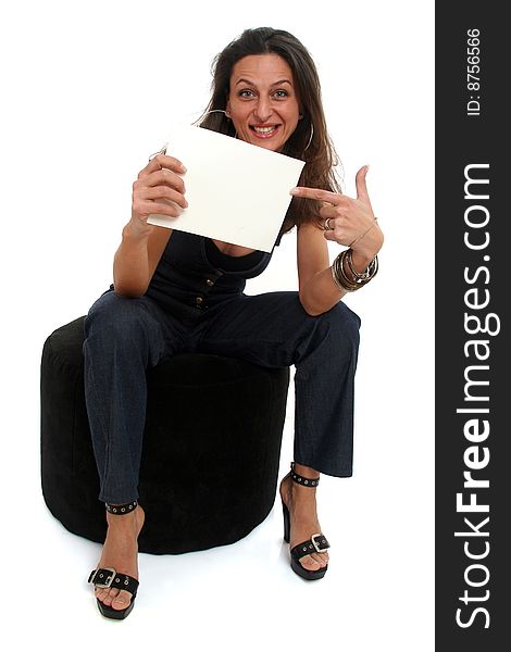 Full body view of attractive woman holding a blank sign and sitting on a pouf in casual wear. Free space for custom message. Isolated on white background. Full body view of attractive woman holding a blank sign and sitting on a pouf in casual wear. Free space for custom message. Isolated on white background.