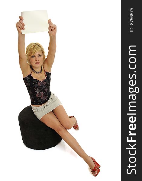 Full body view of attractive woman holding a blank sign and sitting on a pouf in casual wear. Free space for custom message. Isolated on white background. Full body view of attractive woman holding a blank sign and sitting on a pouf in casual wear. Free space for custom message. Isolated on white background.