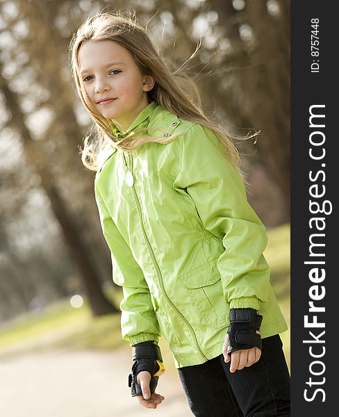 Cute little girl on roller-skates. Blurry background. Cute little girl on roller-skates. Blurry background