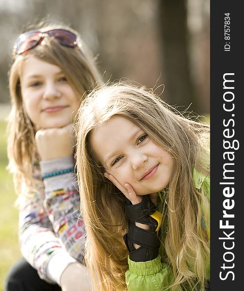 Two happy grils sitting on bench