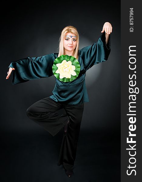 Woman with lotus exercising, studio shot