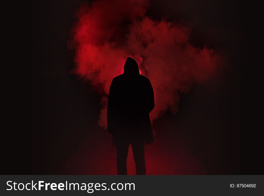Silhouette of Man Standing Against Black And Red Background