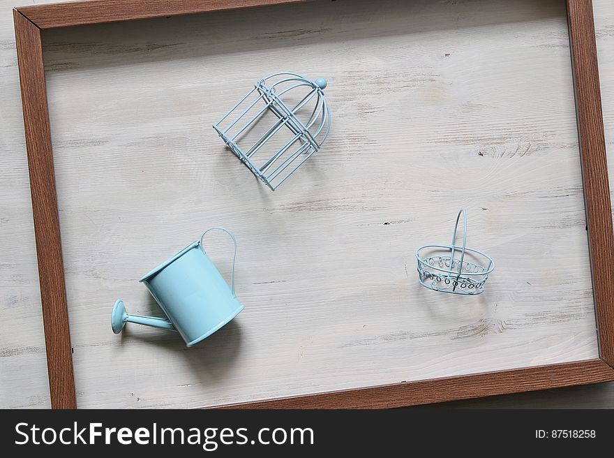 Blue colored toy gardening tools filling a wooden frame on a wooden background. Blue colored toy gardening tools filling a wooden frame on a wooden background