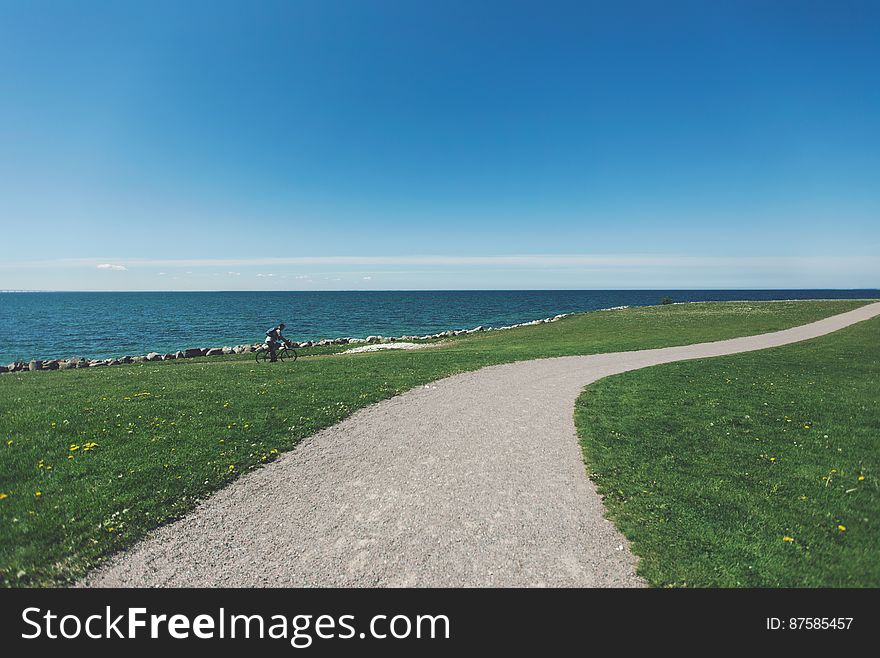Winding Seaside Path With Bicyclist