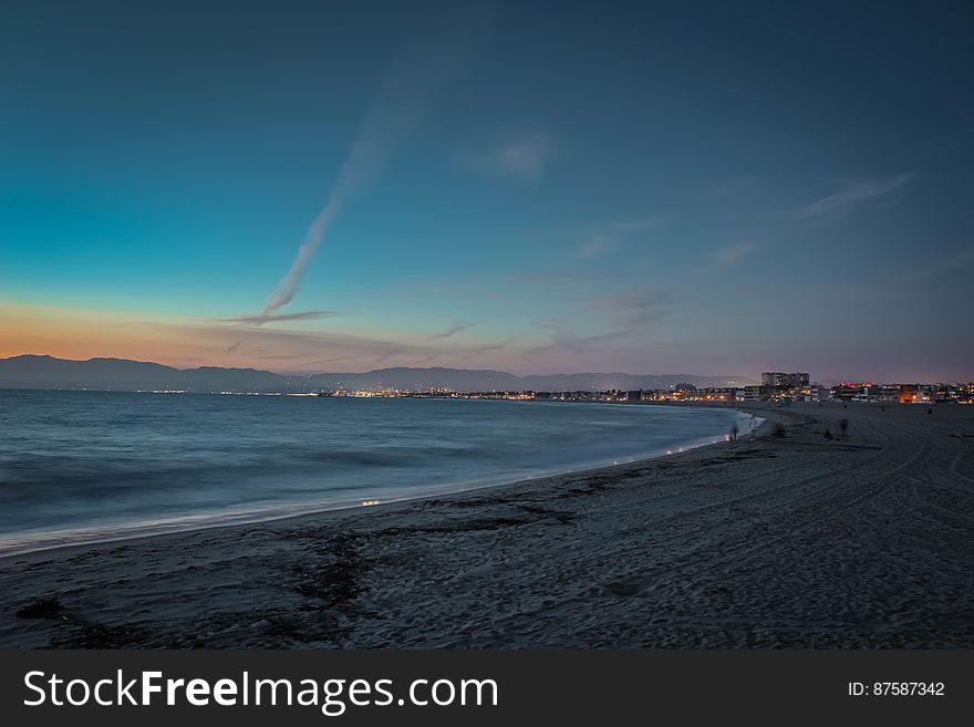 People on Beach&#x27;s Seashore during Sunset