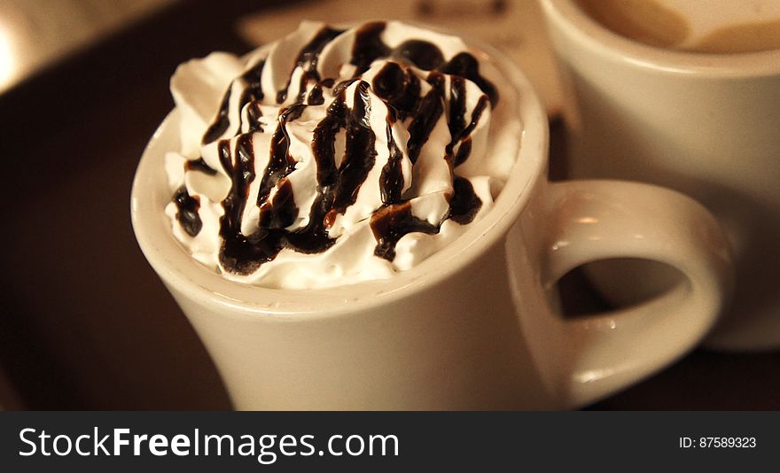 A close up of a cup of hot chocolate with whipped cream on top.