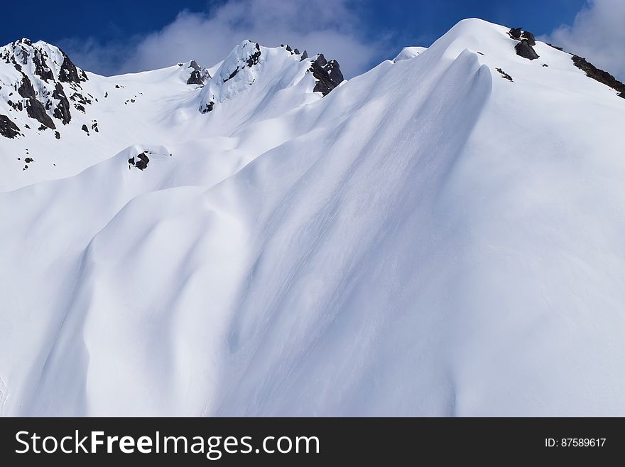 Snowcapped mountain peaks and steep slopes.